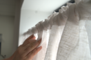 Hands hanging up net curtain