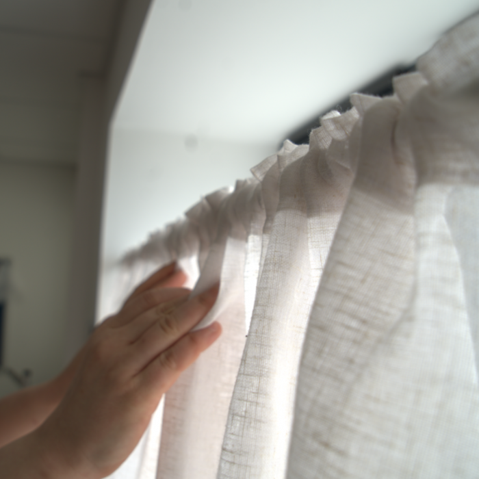 Hands hanging up net curtain
