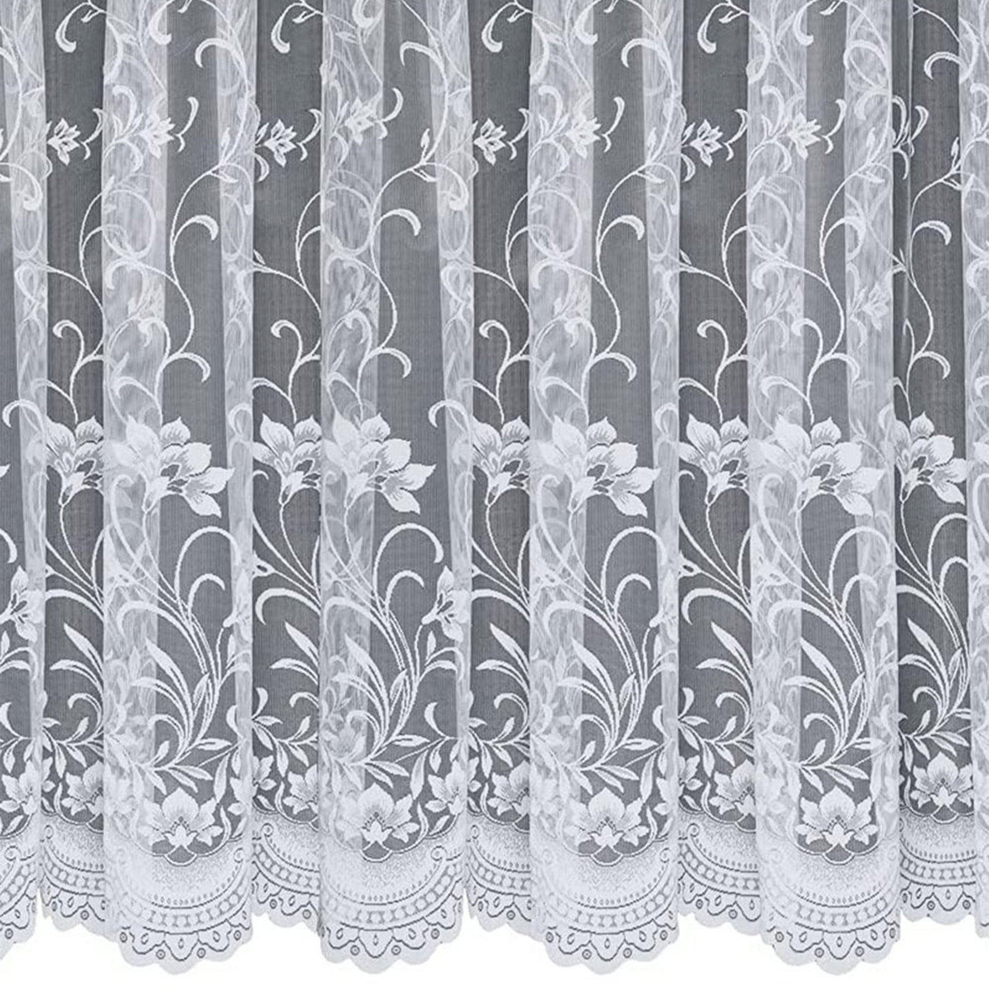 White net curtain with a vertical floral design against a grey background
