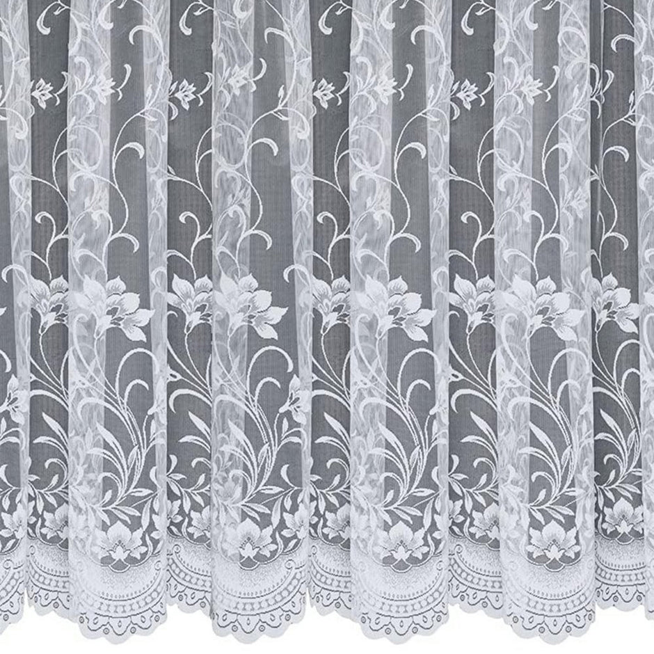 White net curtain with a vertical floral design against a grey background