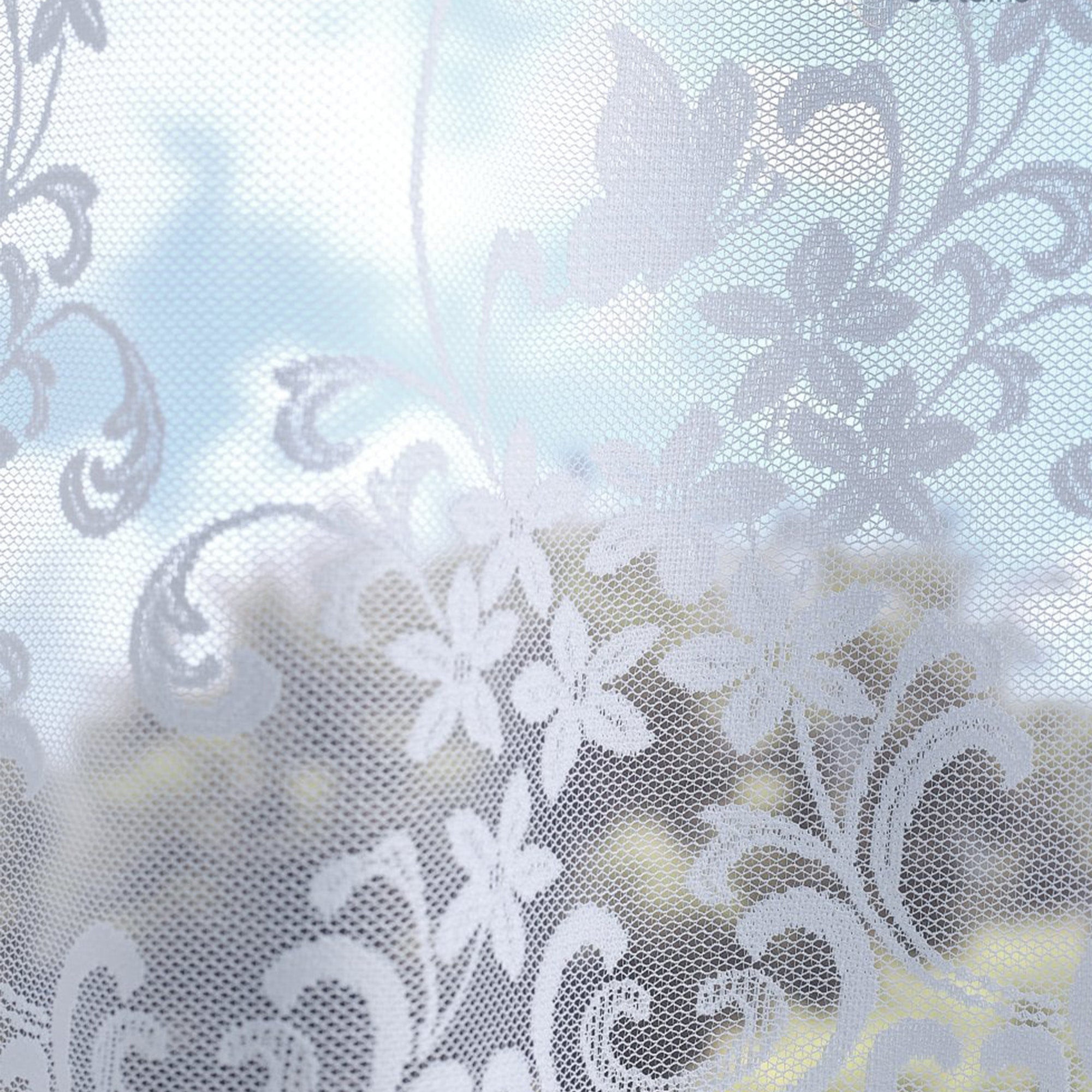 White floral lace net curtains with a soft focus background