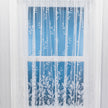 White net curtain with vertical embroidered leaves on a window 
