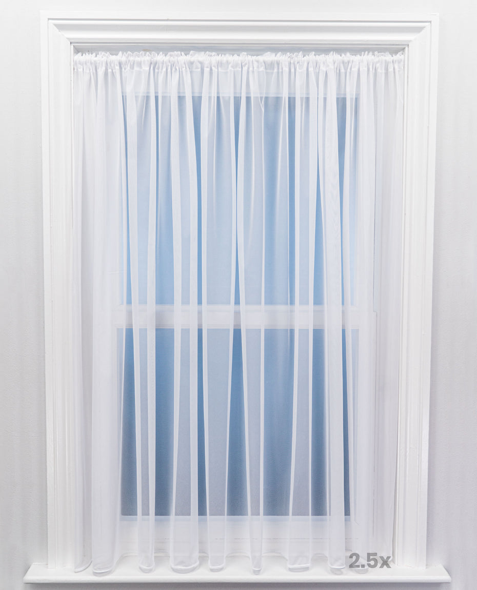 White sheer curtain in front of a window with a white frame.