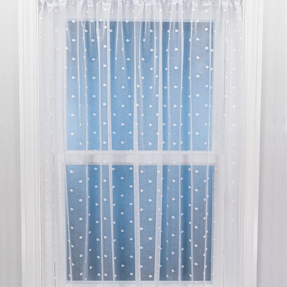 Sheer curtain with white polka dots on a blue background