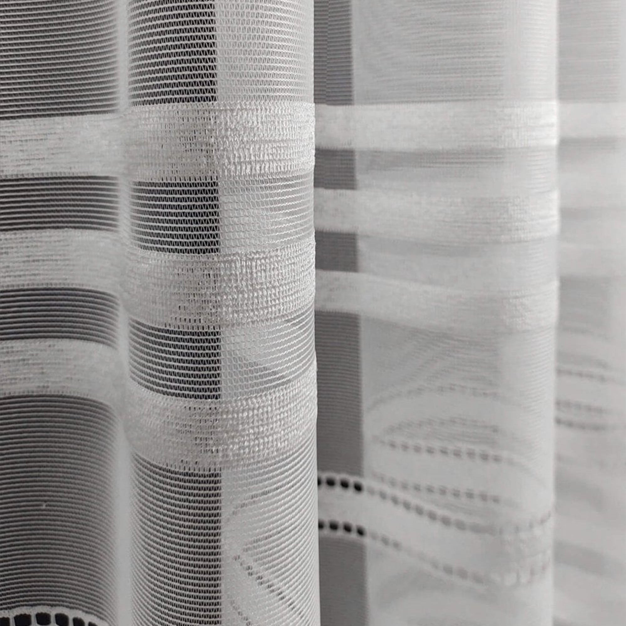 Close-up of a textured white curtain with a stripe pattern