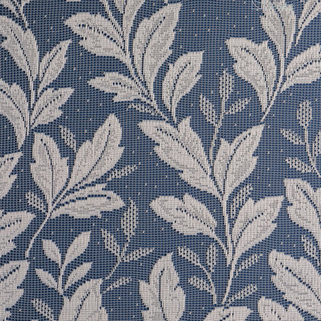 Close up of a white net curtain with embroidered leaves 