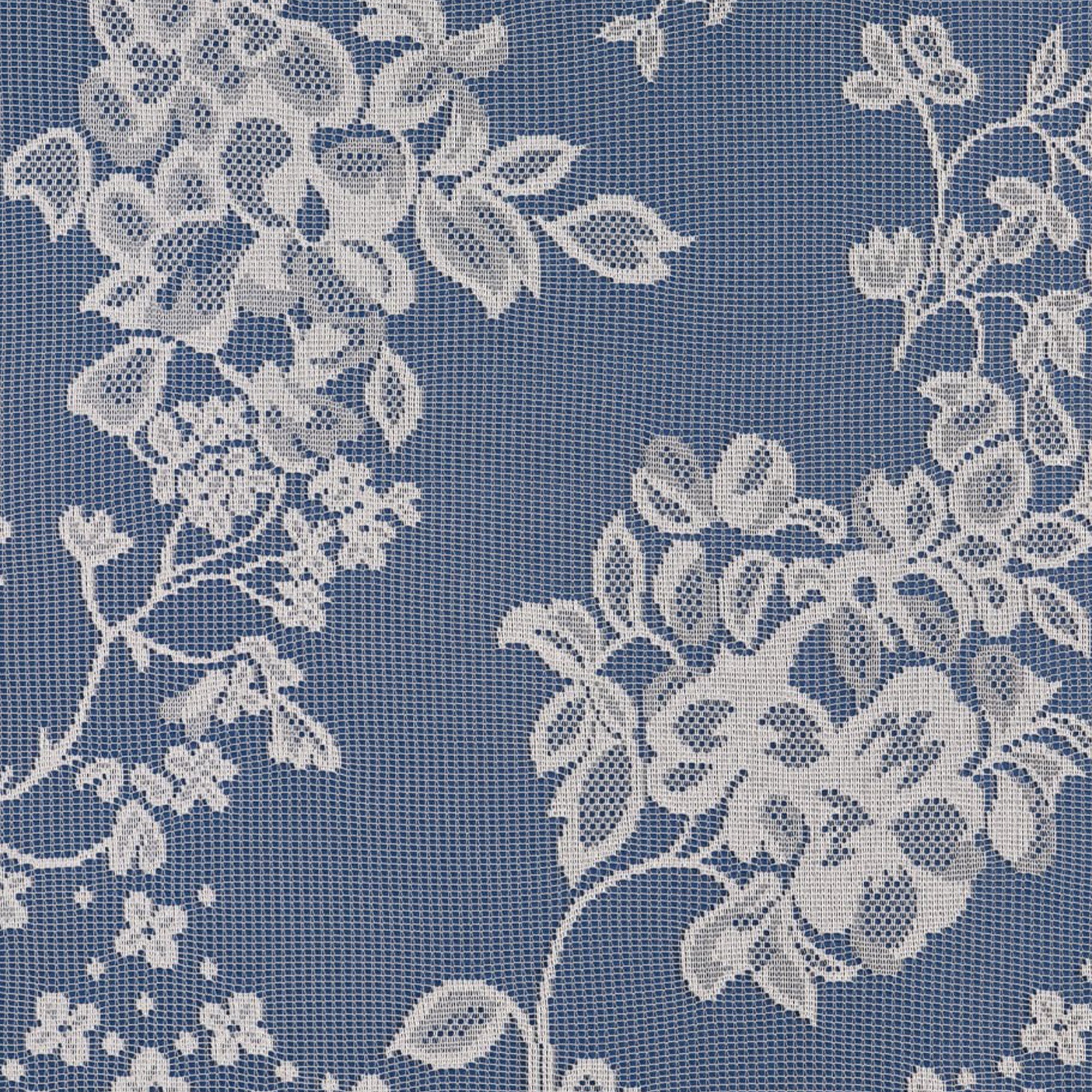 White net curtain with a flower and leaf print against a blue background